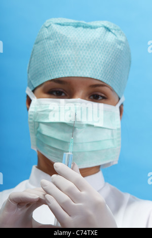 Nurse holding a syringe avec une solution. Selective focus sur la goutte à l'extrémité de l'aiguille. Banque D'Images