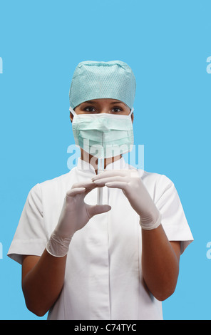 Nurse holding a syringe avec une solution isolée sur un fond bleu. Banque D'Images