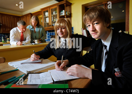 Regardez les parents que des enfants fassent leurs devoirs UK Banque D'Images