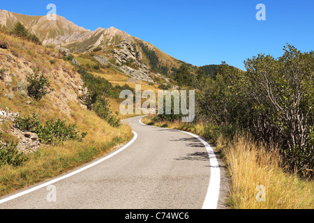 Route étroite qui traverse les collines et les pics des Alpes - montagnes dans le nord de l'Italie. Banque D'Images