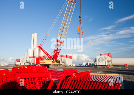 Wind turbine pièces destinées à l'Walneyoffshore wind farm, reflété dans une flaque d'eau sur les quais de Mostyn. Banque D'Images