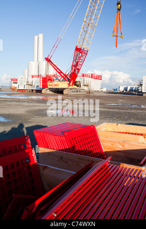 Wind turbine pièces destinées à l'Walneyoffshore wind farm, reflété dans une flaque d'eau sur les quais de Mostyn. Banque D'Images