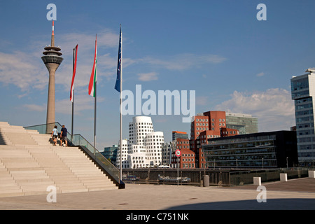 Mâts de drapeau en face de bâtiments conçus par l'architecte américain Frank O. Gehry de port des médias à Duesseldorf, Allemagne Banque D'Images
