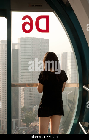 Une jeune chinoise à l'intérieur de la Singapore Flyer ride, Singapour Banque D'Images