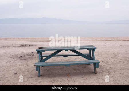 Une pente bleu vide table de pique-nique en bois donnant sur la mer de Salton, California, USA. Banque D'Images