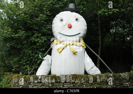 Un grand sourire fait l'épouvantail des balles de foin rondes monte la garde sur une route rurale dans la région de Weardale, Angleterre du Nord-Est, Royaume-Uni. Banque D'Images