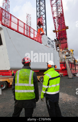 Une nacelle de levage de travailleurs pour une éolienne sur une péniche, à l'aide d'un cric pour l'éolien offshore Walney. Banque D'Images