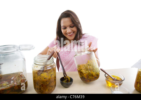 Woman putting pickle dans un bol Banque D'Images