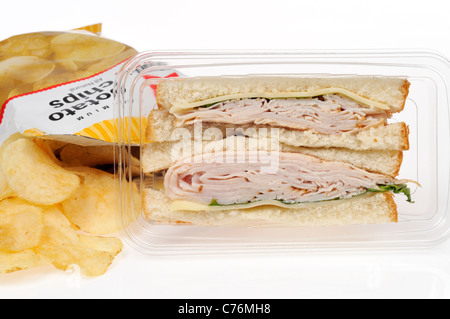 La Turquie et le fromage préparé à emporter sandwich en pack en plastique avec sac de chips ou croustilles de pommes de terre sur fond blanc. Banque D'Images