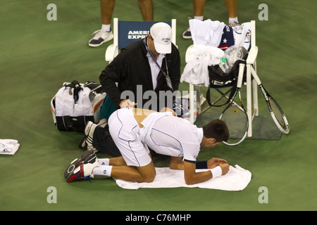 Novak Djokovic (SRB) vainqueur de la finale chez les hommes d'être assisté par le formateur à l'US Open 2011 Tennis Championships. Banque D'Images