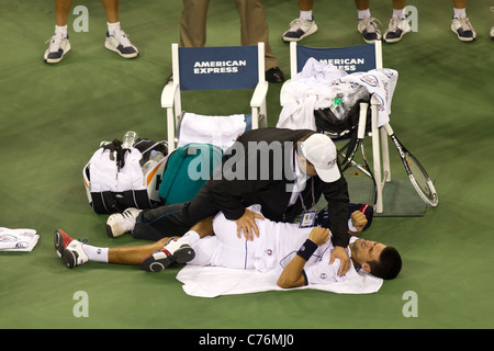 Novak Djokovic (SRB) vainqueur de la finale chez les hommes d'être assisté par le formateur à l'US Open 2011 Tennis Championships. Banque D'Images