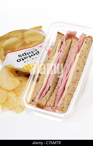 Prêt à emporter, jambon et fromage sandwich en pack en plastique avec un sac de chips sur fond blanc. Banque D'Images