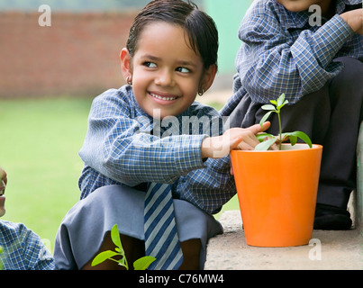 Fille de l'école d'un semis plantation dans un pot Banque D'Images