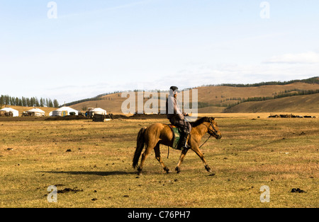 Un homme de Mongolie les prairies d'itinérance sur son cheval. Banque D'Images