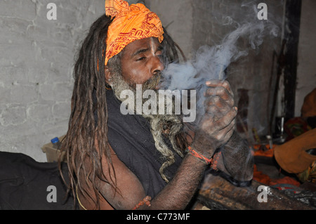 Un Sadhu bénéficiant de fumer de la marijuana à l'occasion de Shiva Ratri' festival dans la région de temple de Pashupatinath, Katmandou, Népal. Banque D'Images