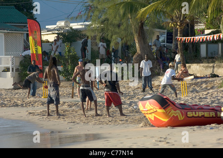 Le batteur est sur le point de frapper la balle à la mer lors d'une soirée de cricket sur plage de Mullins, la Barbade. Banque D'Images