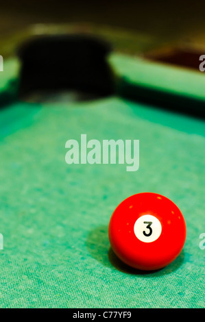 Un gros plan de boule de billard numéro 3, en rouge, pour l'utilisation conceptuelle. Banque D'Images