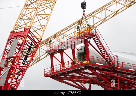 Les aubes de turbine éolienne de chargement sur un cric jusqu'à l'éolien offshore Walney Mostyn à quais. Banque D'Images