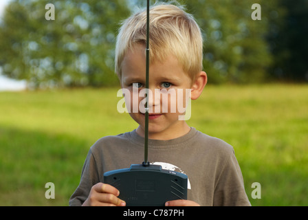 Portrait de jeune enfant garçon blond aux commandes d'un modèle d'avion télécommandé Banque D'Images