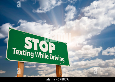 Arrêter de texter au volant panneau vert avec ciel dramatique, Nuages et soleil. Banque D'Images