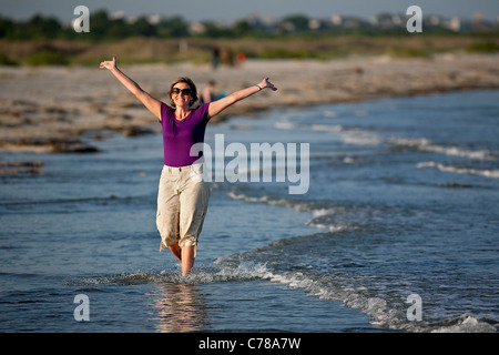 Femme jouit d'elle-même sur la plage de Sullivan's Island, SC. Banque D'Images