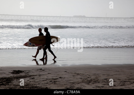 Deux surfeurs de promenade sur la plage à Pimentel sur la côte nord du Pérou près de Chiclayo, près de la maison natale de surf. Banque D'Images