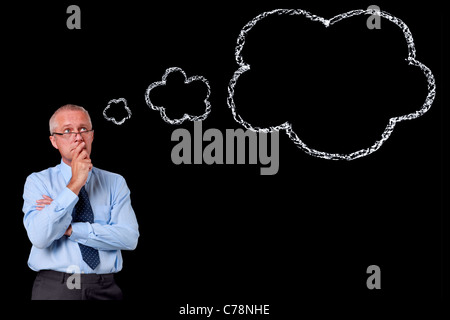 Photo d'un homme d'âge mûr sur un fond noir, de la craie bulle de pensée avec l'exemplaire de l'espace pour ajouter votre propre texte. Banque D'Images