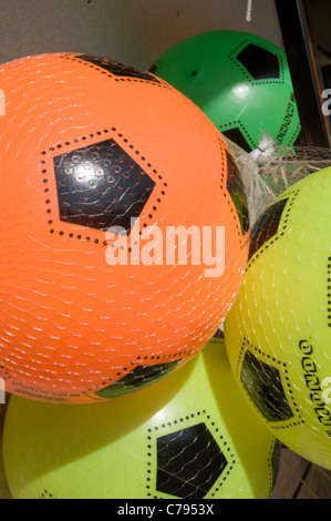 Ballons de football en plastique bon marché foot ball balls brillant couleur coloré couleurs couleurs couleurs vives couleurs plage soccer Banque D'Images