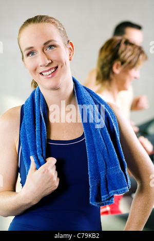 Belle fille prend une pause de son entraînement sur le tapis roulant dans une salle de sport Banque D'Images