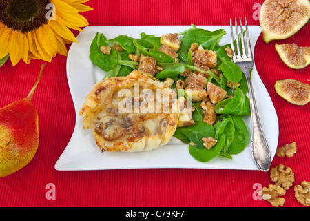 Une tarte feuilletée aux poires et fromage Vacherin, servi avec une salade. Banque D'Images