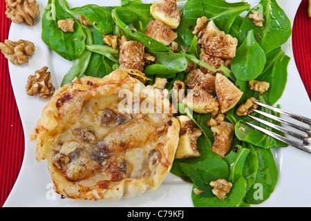 Une tarte feuilletée aux poires et fromage Vacherin, servi avec une salade. Banque D'Images