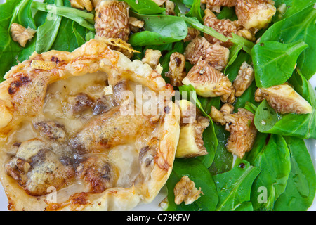 Une tarte feuilletée aux poires et fromage Vacherin, servi avec une salade. Banque D'Images