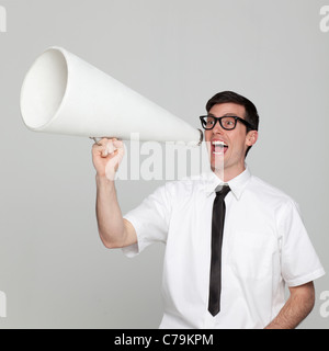Studio portrait of young man with megaphone Banque D'Images
