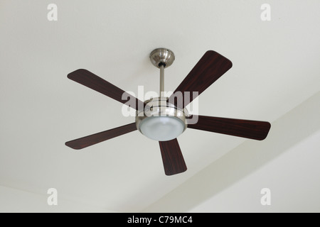 L'argent et le ventilateur de plafond en bois avec une lumière sur le plafond blanc Banque D'Images