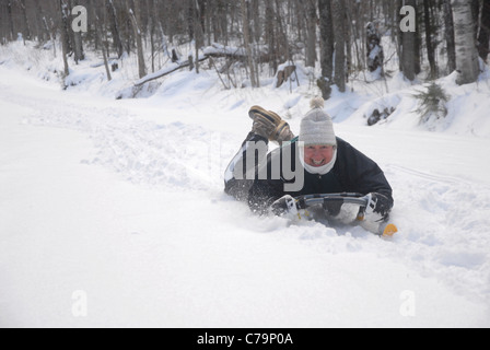 Traîneaux d'une femme sur une colline comme elle aime l'hiver dans le Vermont. Banque D'Images