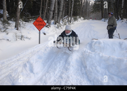 Traîneaux d'une femme sur une colline comme elle aime l'hiver dans le Vermont. Banque D'Images