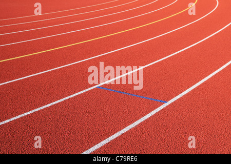 Voies Voie diagonal et tournez à gauche sur une piste en caoutchouc rouge Banque D'Images