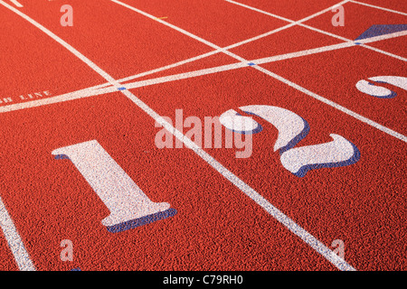 Un et deux voies marquées sur une piste d'athlétisme en caoutchouc rouge Banque D'Images