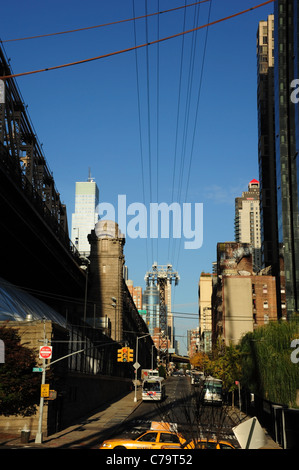 Ciel bleu ensoleillé portrait Queensboro Bridge Tramway aérien au-dessus de la 60e Avenue de New York taxi jaune les entraîneurs, Manhattan, New York Banque D'Images