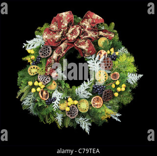 Couronne de Noël avec mini poires et d'autres décorations et d'un arc rouge isolé sur fond noir Banque D'Images