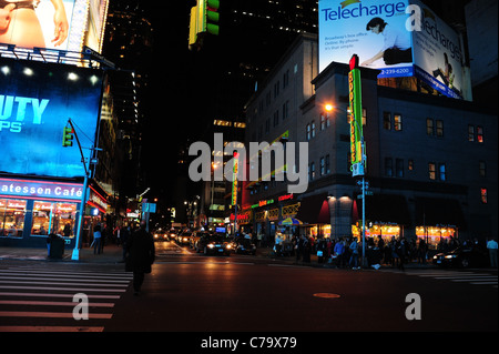 Vue nocturne de l'Applebee's, café, épicerie fine néon bleu trafic phares, l'intersection de la 50e Rue Ouest 7e Avenue, New York Banque D'Images