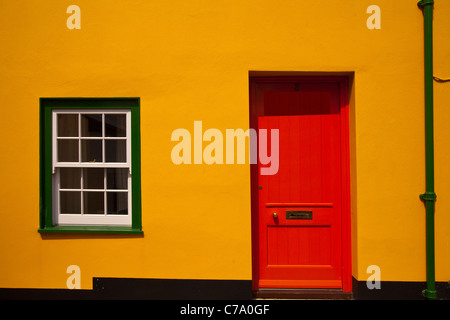 L'avant d'une maison mitoyenne avec une porte rouge et vert windows à Lyme Regis dans le Dorset Banque D'Images