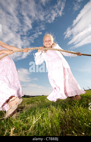 Les enfants qui jouent à la corde sur un pré en été, Eyendorf, Basse-Saxe, Allemagne, Europe Banque D'Images