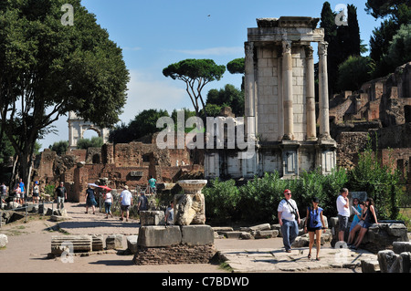 Rome. L'Italie. Les touristes se promener parmi les ruines du Forum Romain (Foro Romano) . Les vestiges du Temple de Vesta (à droite). Banque D'Images