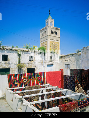 Tunis, Tunisie, Afrique du Nord, l'ancienne Médina, de tapis tissés à la main afficher sur la terrasse du toit, minaret mosquée Zitouna, Banque D'Images