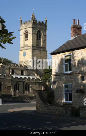 400 ans ferme en pierre calcaire avec l'église St Pierre en arrière-plan, Barnburgh, Yorkshire, Angleterre. Banque D'Images