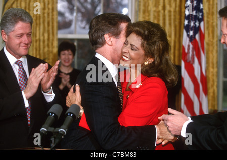 Le Secrétaire à la défense, William Cohen est étreint par son épouse, Janet Langhart comme le président Bill Clinton a l'air sur Banque D'Images