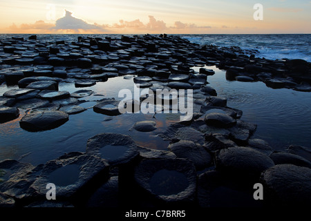 Colonnes de basalte partiellement submergé à Giant's Causeway près de Sunset, comté d'Antrim, en Irlande du Nord, Royaume-Uni Banque D'Images