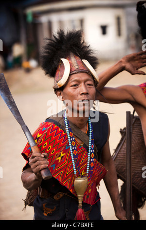 L'Inde, Nagaland ; Longwa ; Konyak guerriers Naga en vêtements traditionnels exerçant son couteau de combat Banque D'Images