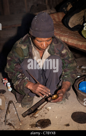 L'Inde, Nagaland, Naga Konyak Longwa, en remuant la cuillère sur l'opium de l'homme Banque D'Images